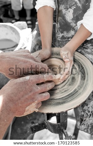 hand of the potter and the child in the creation of new products from clay