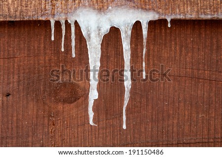 icicles hanging down on a wooden wall