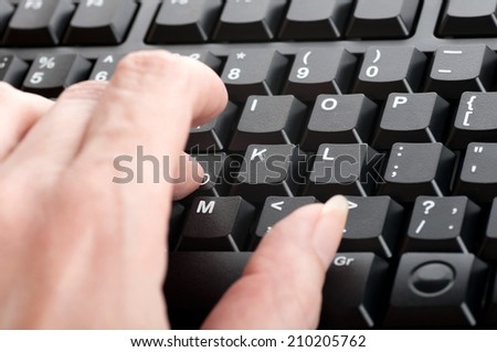 women\'s fingers press a key on the keyboard