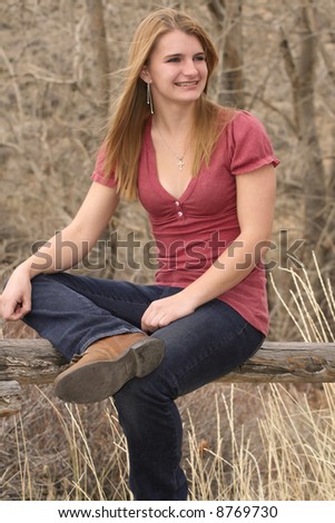 Pretty young woman sitting outside smiling