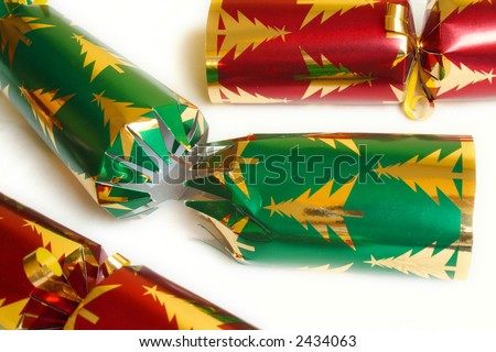 Pulled Christmas Cracker isolated on white with two other unpulled crackers