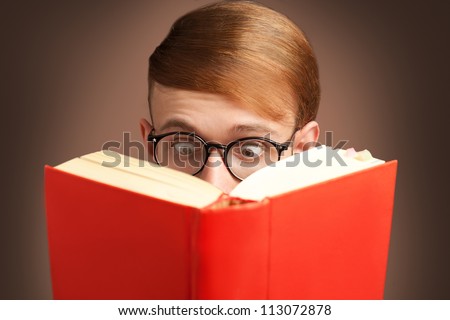 amazed nerd reading a red book with eyeglasses