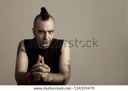 portrait of a tattooed young man with punk style hair