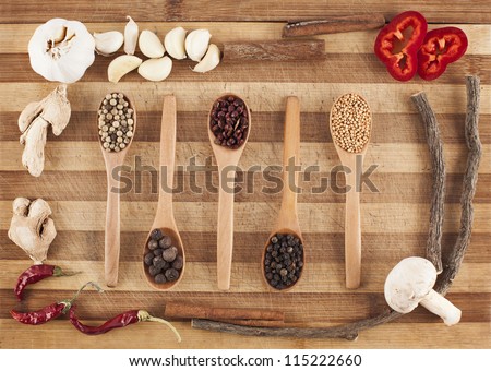 five spoons of spices in a vegetable frame on cutting board