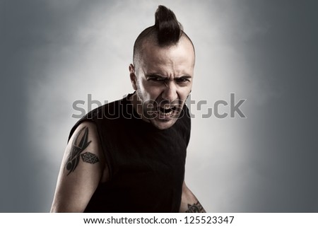 tattooed young man with mohawk style hair screaming