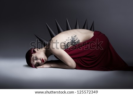 young monster girl sleeping on the floor on dark background