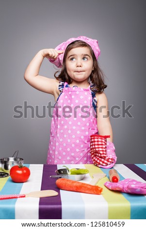 little chef in pink uniform thinking what to cook