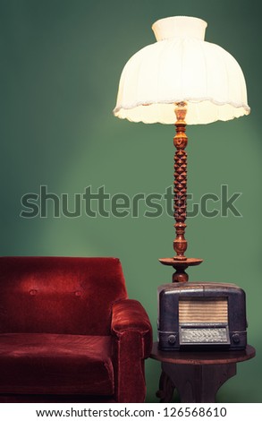 decoration with vintage sofa,shade lamp and a radio on green background