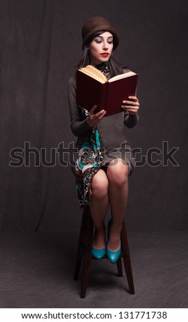 beautiful lady sitting on a stool and reading a book on grunge background
