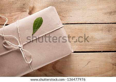 gift box with a green leaf on it on wooden background gift box with a green leaf on it on wooden background
