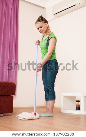 beautiful young lady wearing casual clothes, mopping the floor
