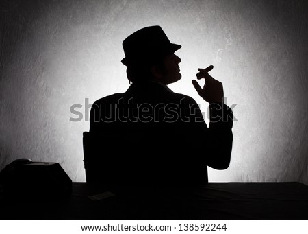 silhouette of retro style gangster holding his cigar on grunge background