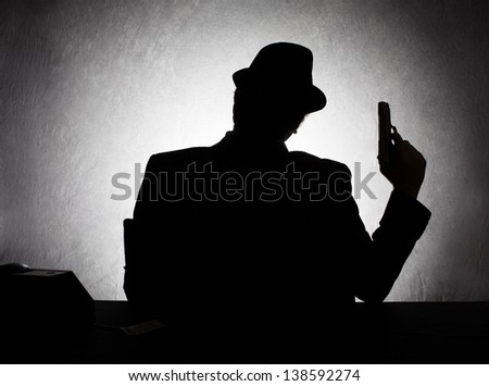 Silhouette Of Retro Style Gangster Holding His Gun On Grunge Background