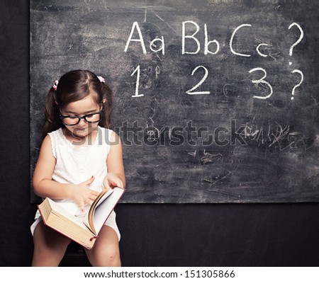 little cute girls looking for answers in front of blackboard little cute girls looking for answers in front of blackboard
