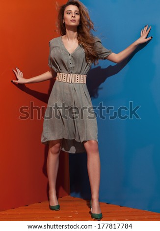 beautiful young lady with green spring dress on blue and red background