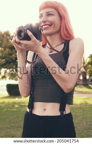retro filtered photograph of a hipster girl with an analog camera