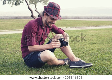 retro filtered photograph of a hipster guy with an analog camera