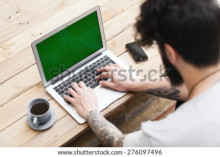 hipster guy with tattooed arm using a laptop.focus on keyboard