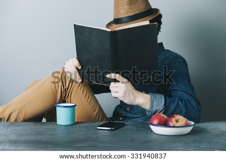 young hipster man reading a book and relaxing