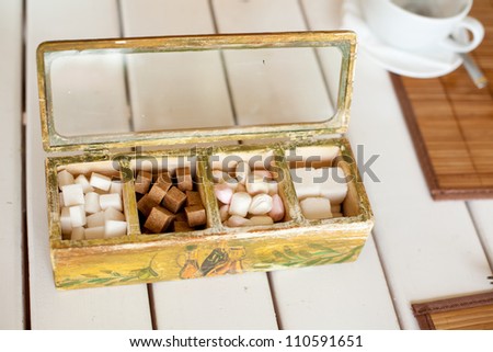 Various kinds of sugar and candies in wooden box
