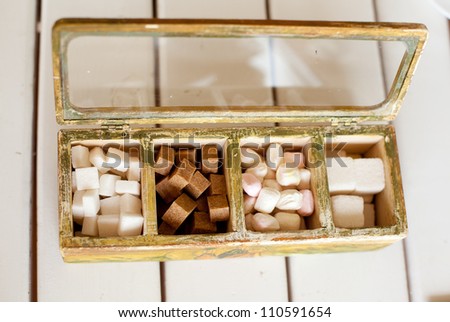 Various kinds of sugar and candies in wooden box