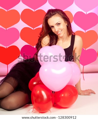 Portrait of pretty young woman over heart-made background, love concept