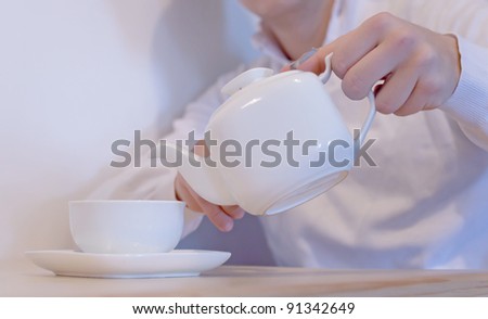 Christmas time. Handsome young man pouring tea in cup