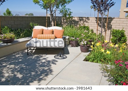 Backyard oasis and suburban retreat with flowers, lounge chair, and patio