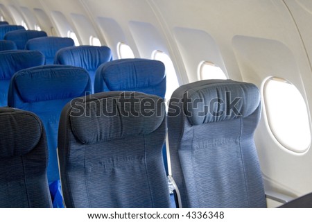 Passengers inside an airplane going to their aircraft seats