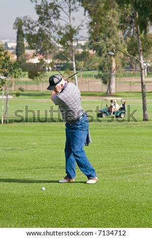 A golfer plays a round of golf at the country club resort