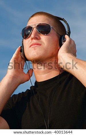 A cool young man listens to music on some headphones