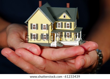 Woman holding a hand-made house model.