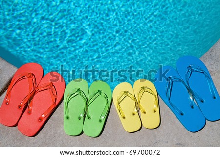 Colored flipflops of a family of four by the swimming pool
