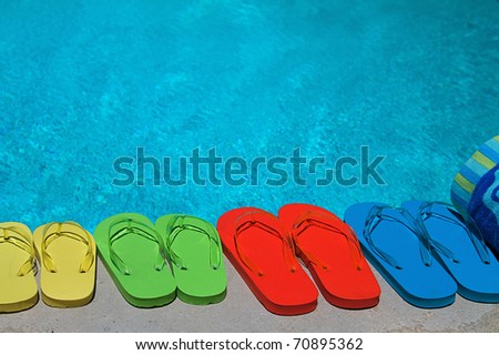 Colored flipflops of a family of four by the swimming pool