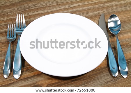 Modern silverware arranged in a place setting on a table