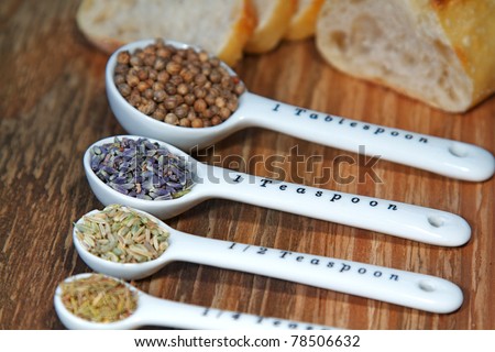 Old table-top selection of herbs and grains in measuring spoons
