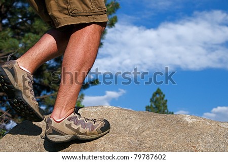 Trail runner climbing a steep rock in his path