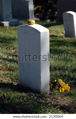 Deceased family member remembered at Halloween and or Thanksgiving. Flowers and a single pumpkin left at the grave in Arlington National Cemetary.