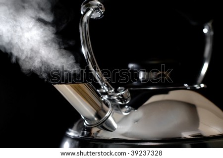Close up shot of steaming tea kettle. Shallow depth of field; focus on the tip and steam.