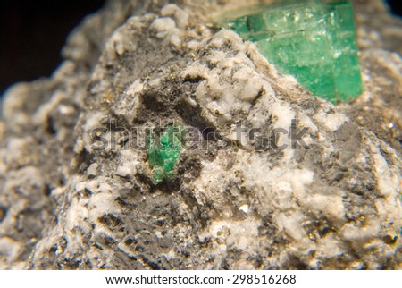 rough gemstone emeralds in granite and quartz