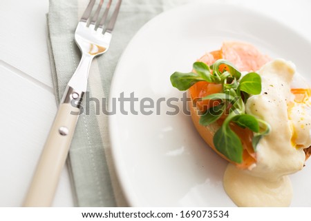 Poached eggs royale with salmon, sauce hollandaise, salad and fresh orange juice