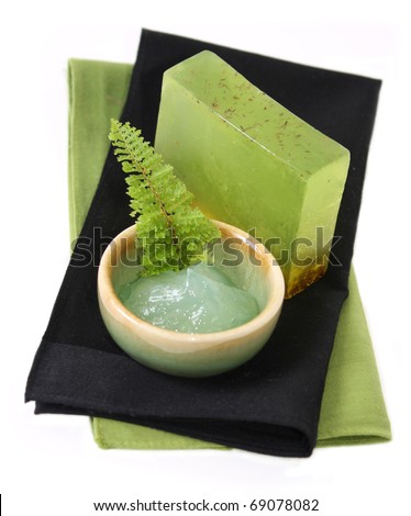 green spa products, lemongrass spa soap and facial treatment gel on black and green fabric