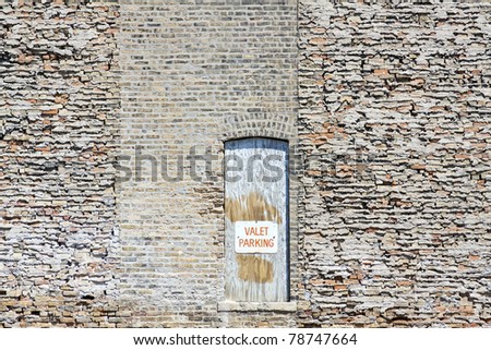 Valet Parking Sign on old wooden door with brick wall background