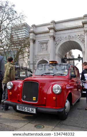 LONDON - APRIL 7 : A London Taxi at Marble Arch on April 7, 2013 in London, UK. Not all London cabs are black, but all  undergo a strict annual mechanical test before they are allowed to ply for hire.