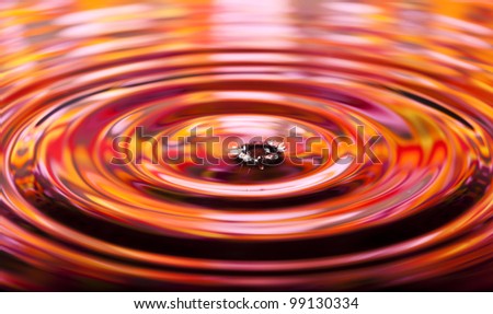Wavy circles on the water, red and orange reflections.