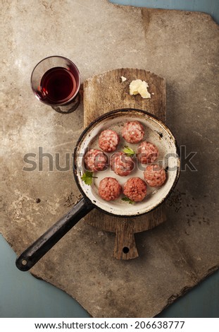 Meatballs cooking with mince, parsley, parmesan, wine and eggs.