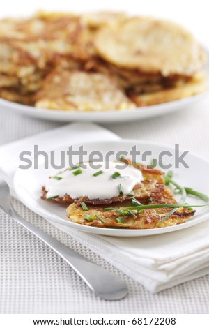 Potato pancakes on plate with sour cream