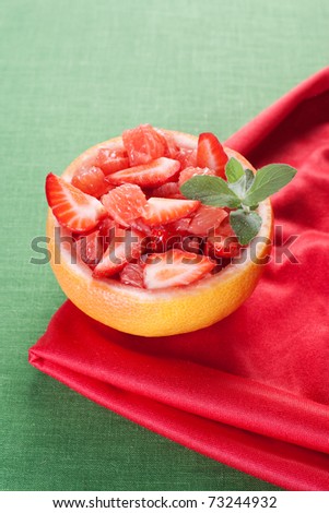 Fruit salad in hollowed-out grapefruit stuffed with strawberry