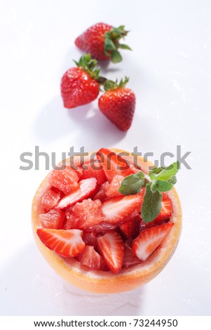 Fruit salad in hollowed-out grapefruit stuffed with strawberry
