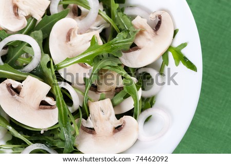 Fresh salad with rucola, mushrooms and onion in bowl